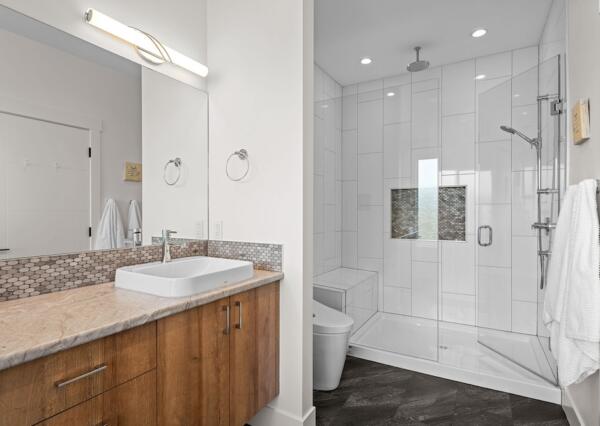 Large tiled shower in primary suite of custom design home