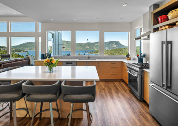 Large l-shaped kitchen with light wood cabinetry and white countertops