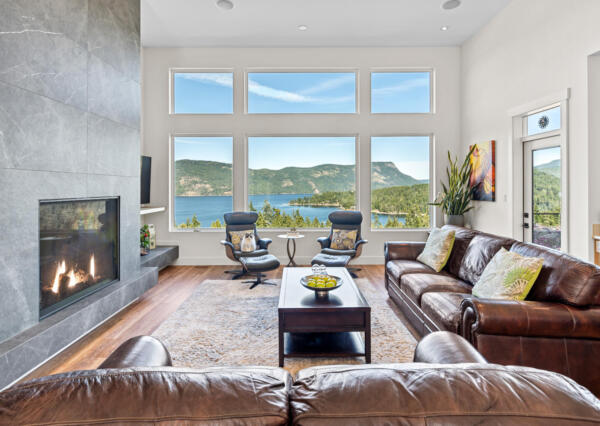 Tall ceilings and windows in open concept living room with gas fireplace