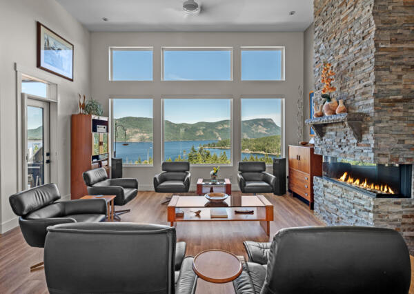 Three sided gas fireplace with rock and ocean view living room