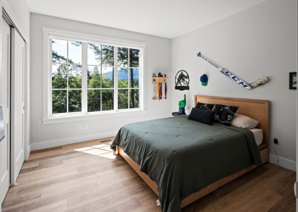 Kids bedroom with large window and wood flooring