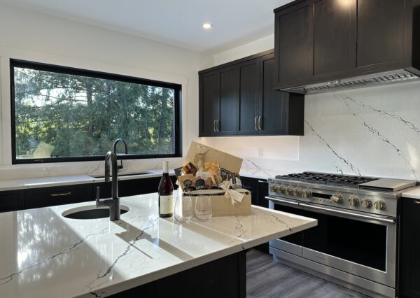 Bright kitchen with black cabinetry, gold hardware and large kitchen island