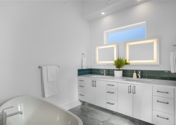 Freestanding bathtub with white dual vanity in master ensuite