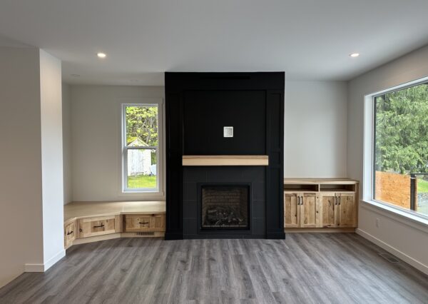 Great room with black gas fireplace and built in storage