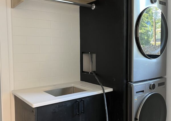 Laundry room with wood and black cabinetry