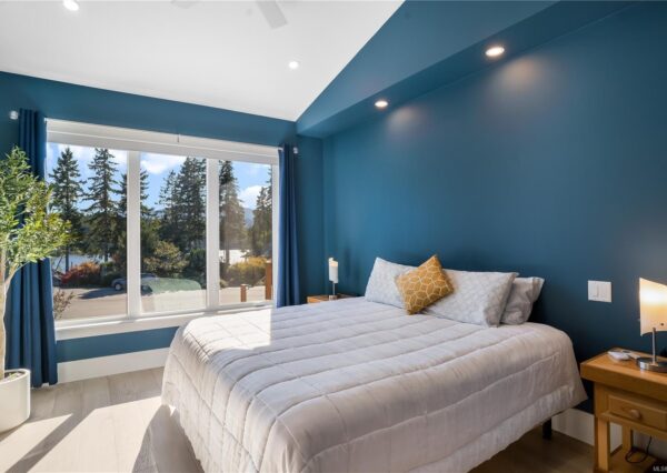 Blue master bedroom with lake views and large window