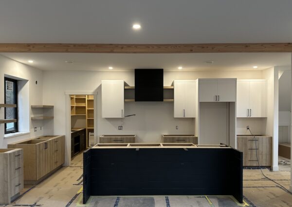 Large custom designed kitchen with black, white and wood cabinetry